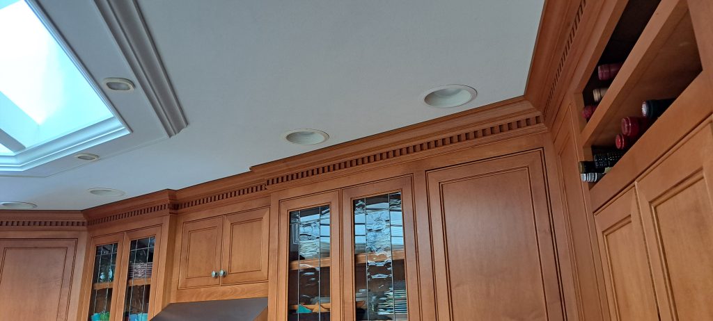 Recessed light fixtures in kitchen ceiling above built-in cabinets